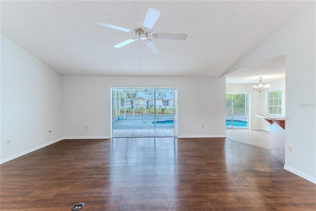 2489 Amherst Avenue Spring Hill, FL 34609 - Photo 13 of 45 a view of an empty room with wooden floor and a window