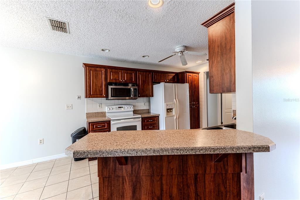 2489 Amherst Avenue Spring Hill, FL 34609 - Photo 14 of 45 a kitchen with refrigerator and kitchen island