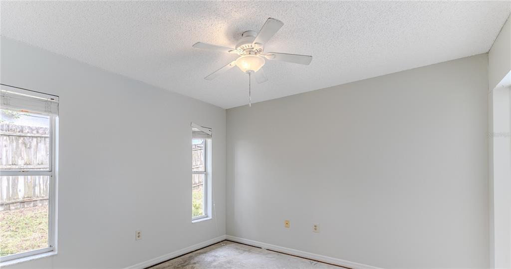 2489 Amherst Avenue Spring Hill, FL 34609 - Photo 30 of 45 an empty room with windows and fan