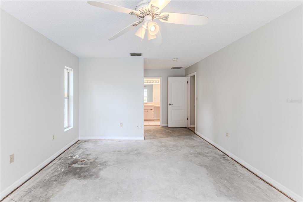 2489 Amherst Avenue Spring Hill, FL 34609 - Photo 32 of 45 an empty room with a ceiling fan and a window
