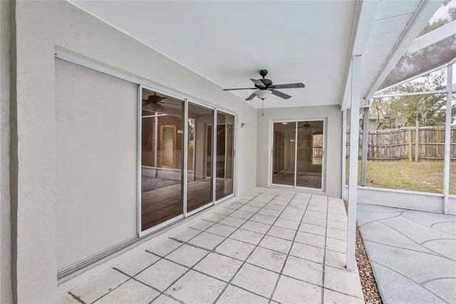 a view of empty room with window and ceiling fan