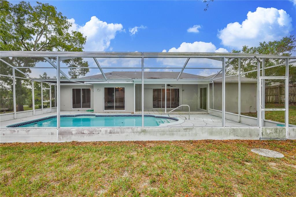 2489 Amherst Avenue Spring Hill, FL 34609 - Photo 41 of 45 a view of a house with a backyard and a large tree