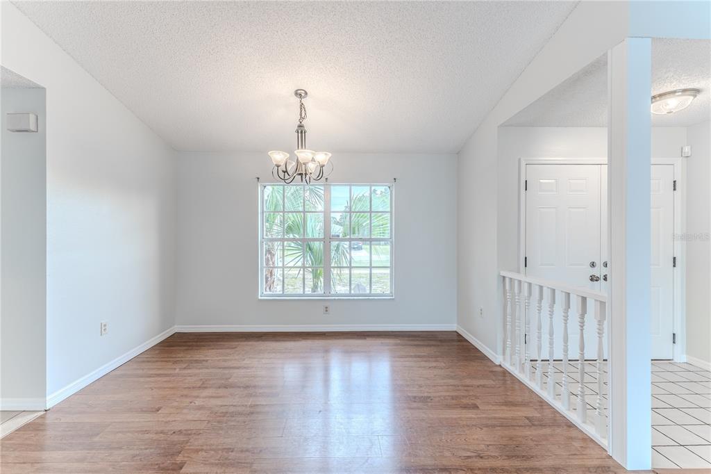 2489 Amherst Avenue Spring Hill, FL 34609 - Photo 9 of 45 an empty room with wooden floor chandelier and closet