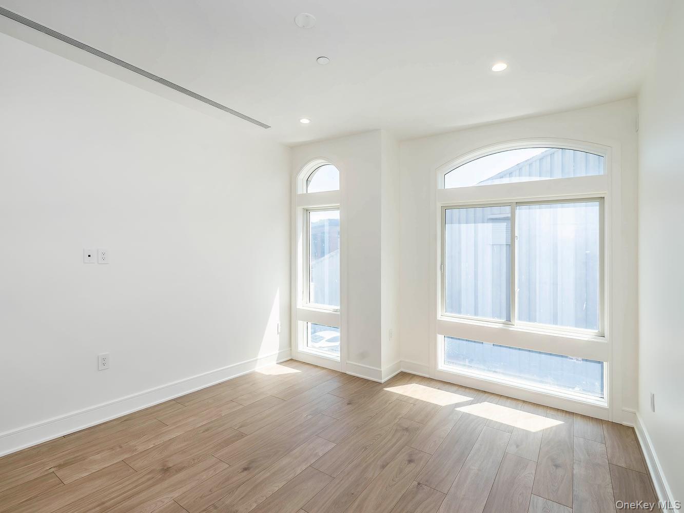 24 Lumber Road, Unit 2 Roslyn, NY 11576 - Photo 14 of 25 an empty room with wooden floor and windows