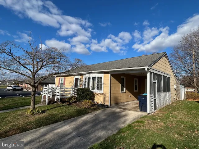 a view of a white house with a large tree