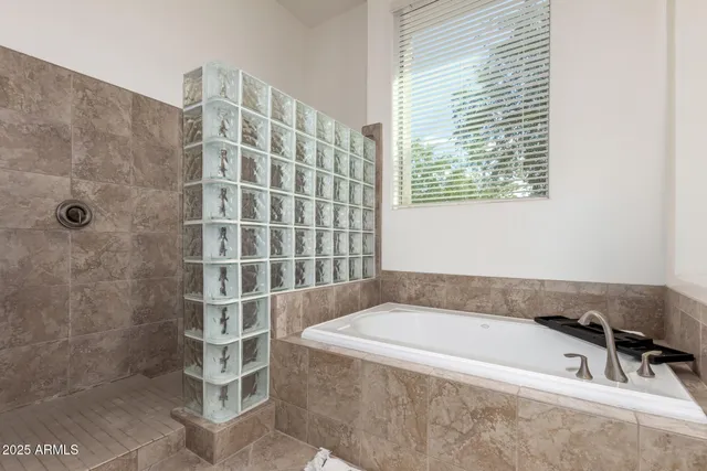 a bathroom with a granite countertop sink a mirror and shower