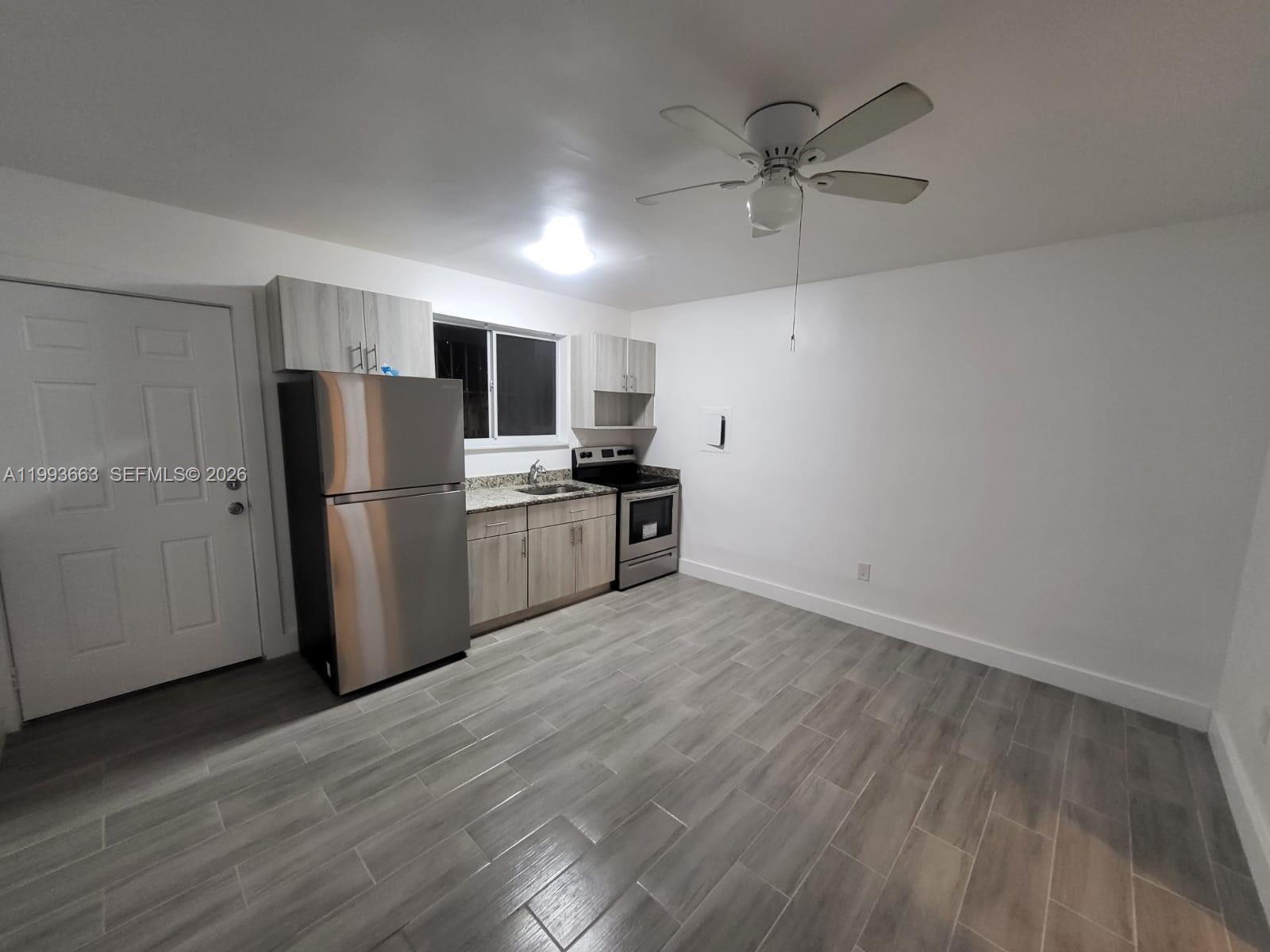 599 Northwest 33rd Street Miami, FL 33127 - Photo 4 of 8 a kitchen with stainless steel appliances a refrigerator and a stove top oven
