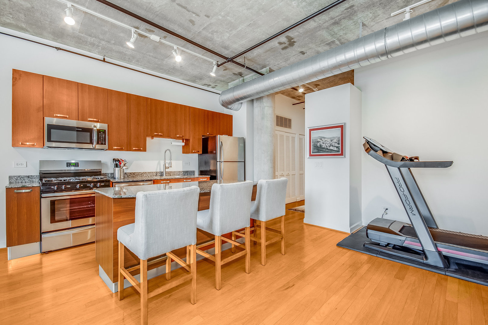 111 South Morgan Street, Unit 416 Chicago, IL 60607 - Photo 5 of 15 a kitchen with stainless steel appliances granite countertop a stove top oven a sink a dining table and chairs with wooden floor