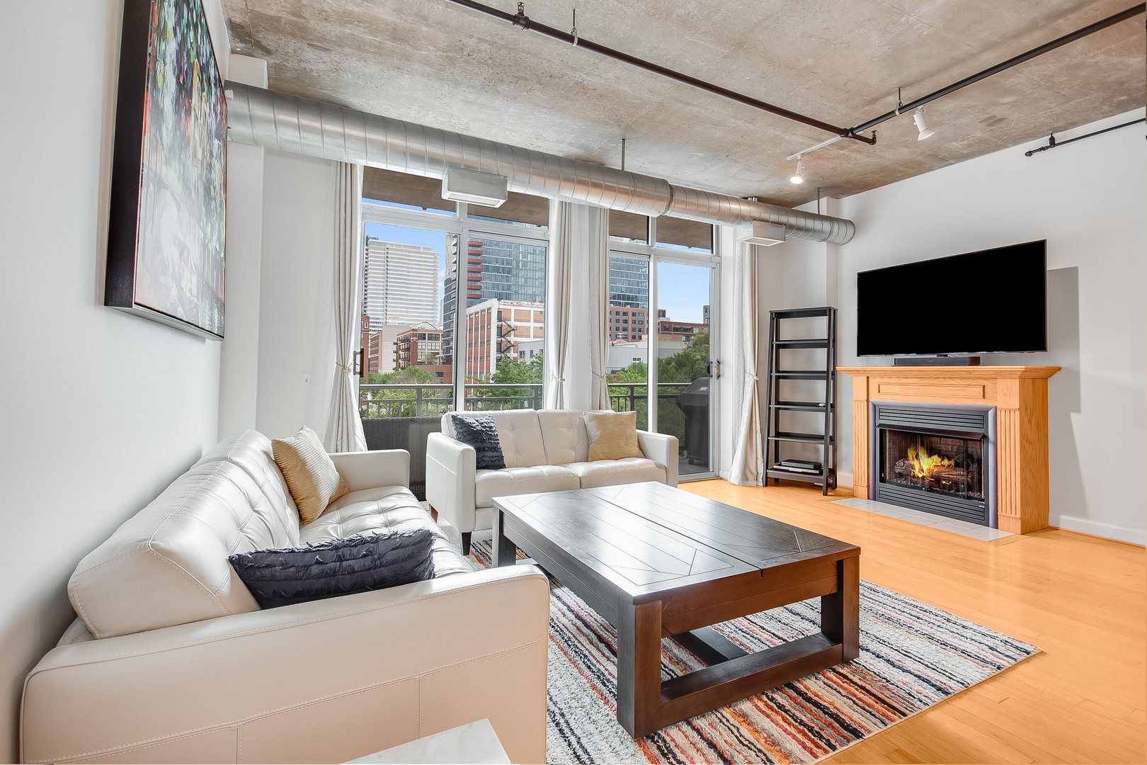 111 South Morgan Street, Unit 416 Chicago, IL 60607 - Photo 6 of 15 a living room with furniture a fireplace and a flat screen tv