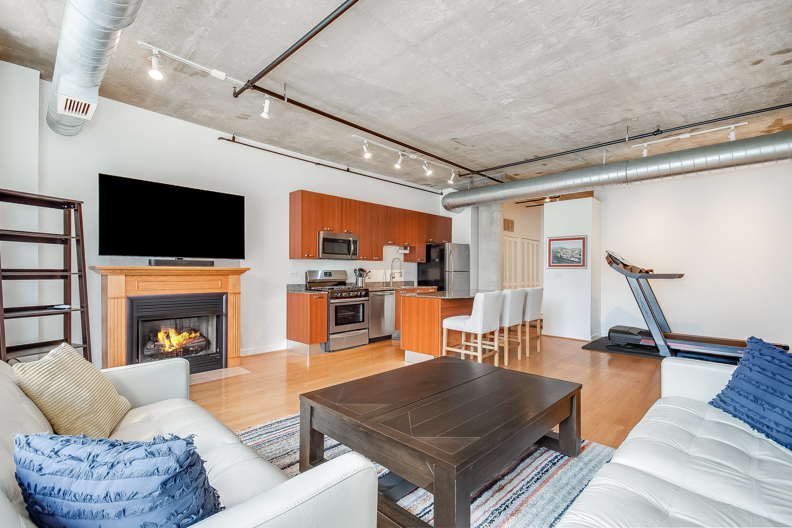 111 South Morgan Street, Unit 416 Chicago, IL 60607 - Photo 7 of 15 a living room with furniture a fireplace and flat screen tv