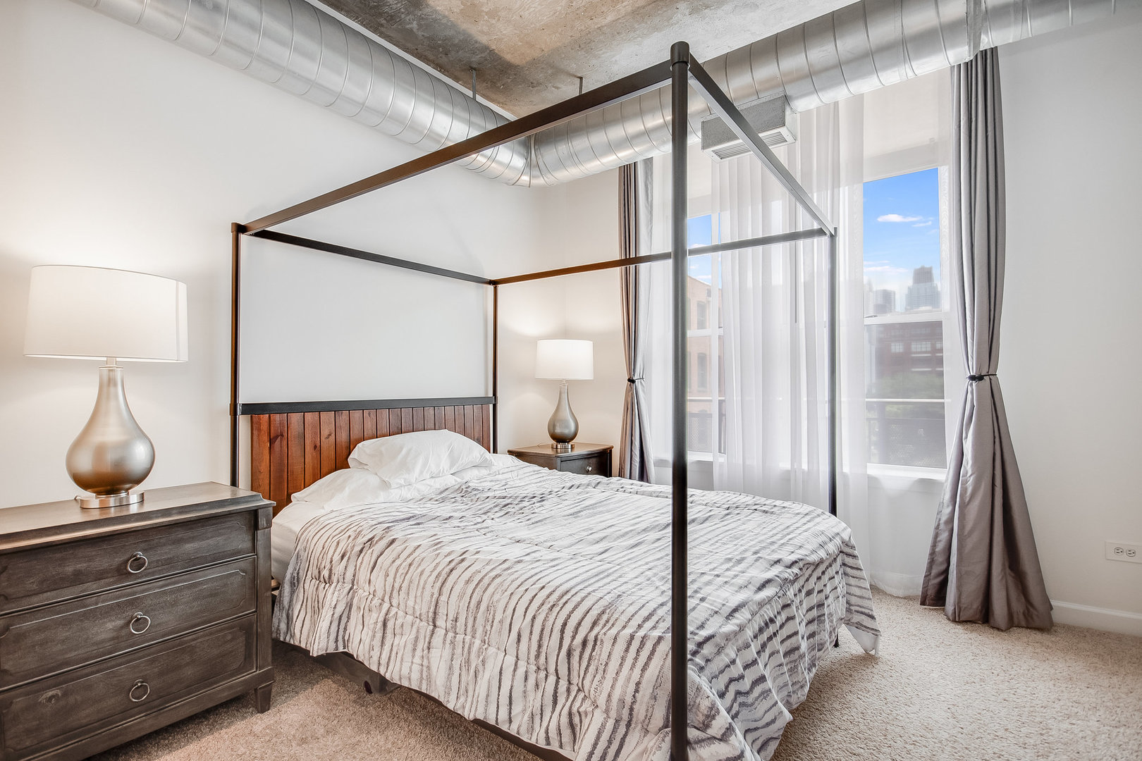 111 South Morgan Street, Unit 416 Chicago, IL 60607 - Photo 10 of 15 a bedroom with a bed and a lamp