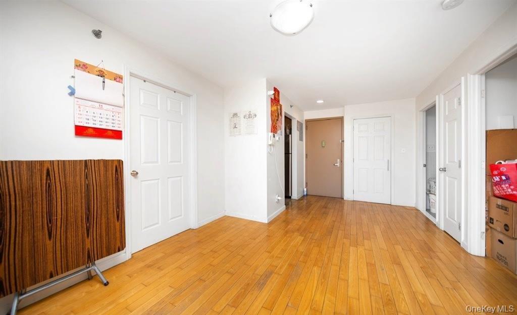 136-16 35th Avenue, Unit 7C Queens, NY 11354 - Photo 7 of 19 a view of a bedroom with wooden floor and closet