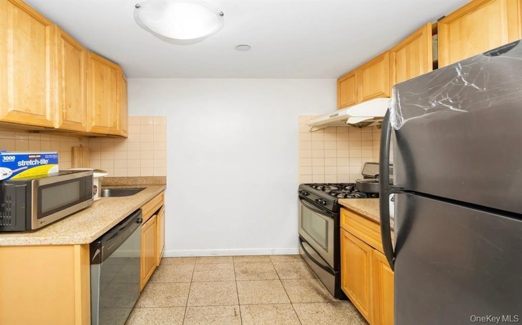 136-16 35th Avenue, Unit 7C Queens, NY 11354 - Photo 10 of 19 a kitchen with a stove top oven and cabinets