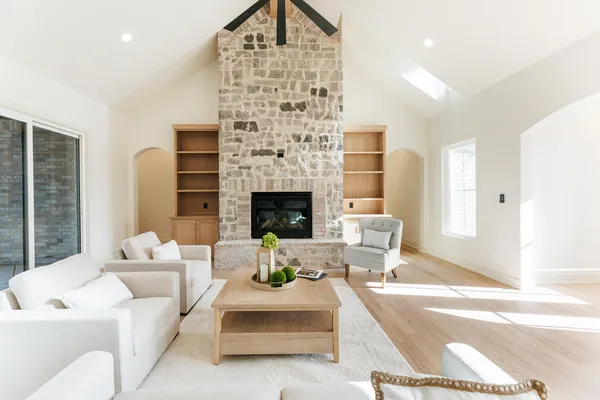 a large kitchen with a center island wooden floor stainless steel appliances and windows