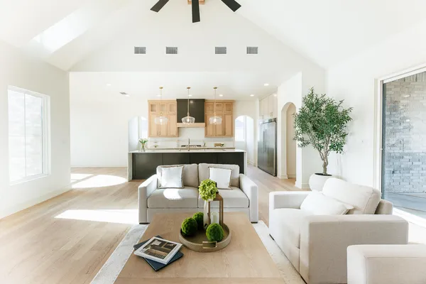 a kitchen with stainless steel appliances a sink a chandelier a stove and white cabinets
