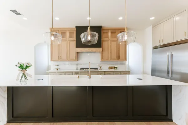 a kitchen with stainless steel appliances cabinets and a wooden floor