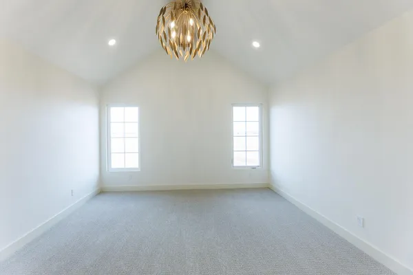 a view of a hallway with wooden floor and chandelier
