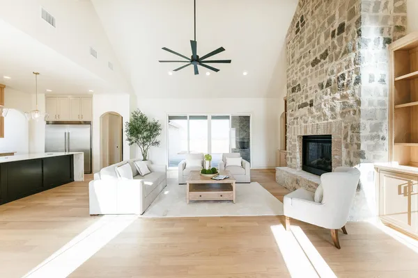 a living room with furniture a fireplace and a chandelier