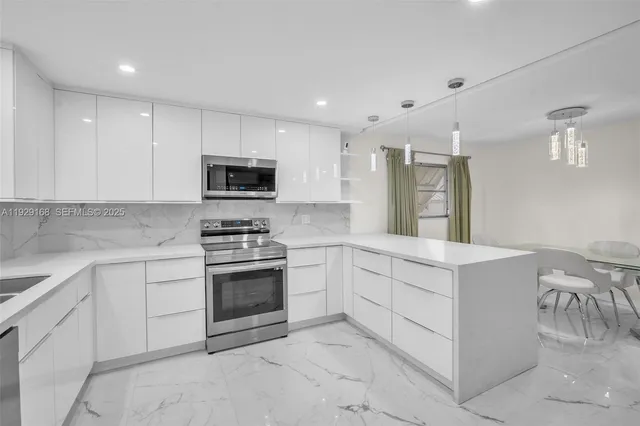 a kitchen with granite countertop white cabinets and stainless steel appliances