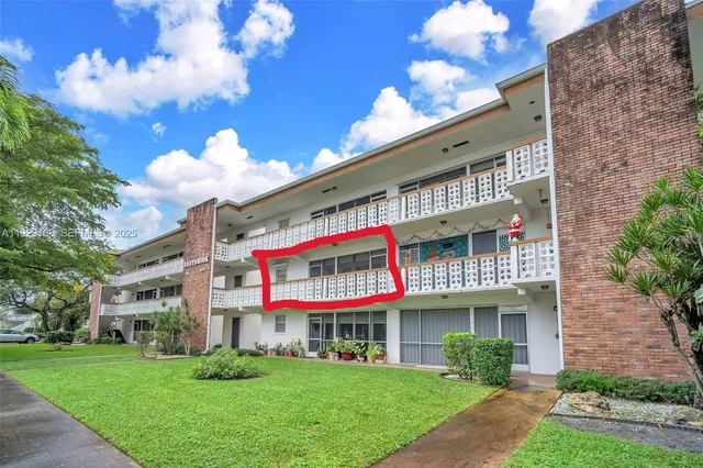 a front view of multi story residential apartment building with yard