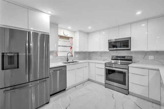 a kitchen with stainless steel appliances granite countertop a refrigerator stove and sink