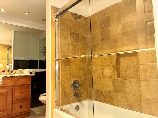 a kitchen with granite countertop white cabinets and black appliances