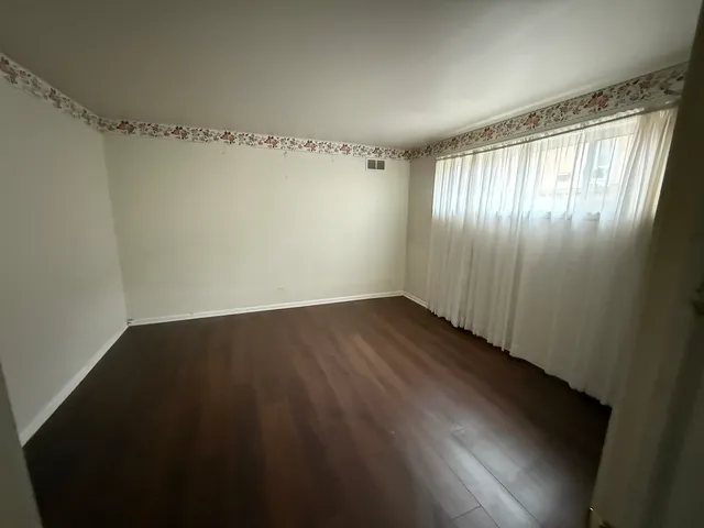 a view of a hallway with wooden floor and entryway