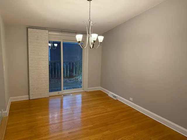 a view of a room with wooden floor chandelier and entryway