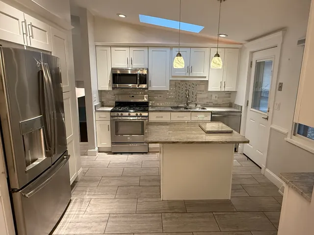 a kitchen with stainless steel appliances granite countertop a refrigerator sink and stove