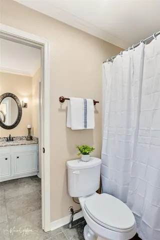 a bathroom with a granite countertop toilet sink and mirror