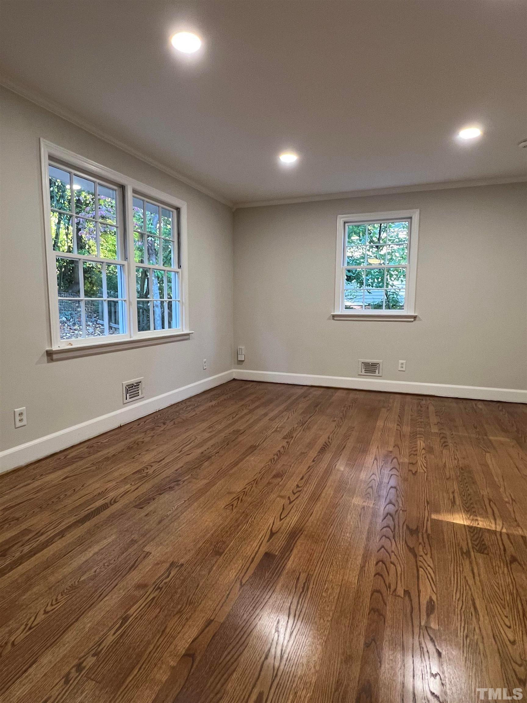 913 Brookwood Drive Raleigh, NC 27607 - Photo 22 of 23 an empty room with wooden floor and windows