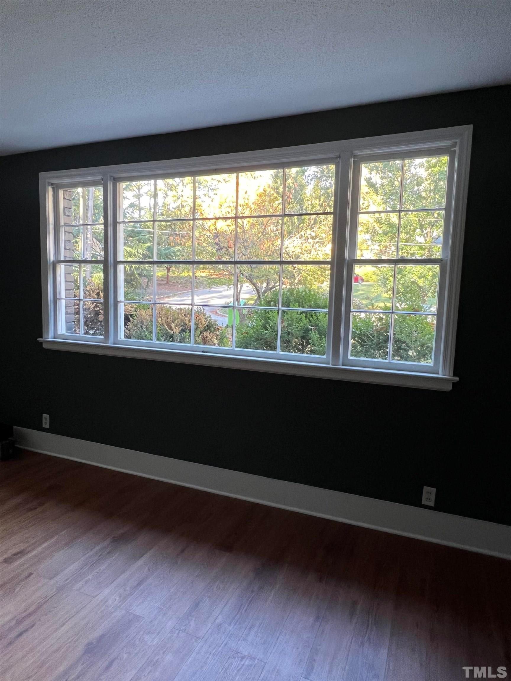 913 Brookwood Drive Raleigh, NC 27607 - Photo 8 of 23 a view of empty room with wooden floor and fan