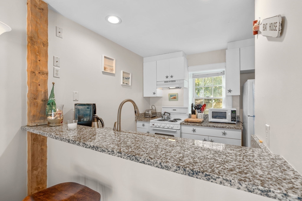 6 Hammock Pond Road, Unit 6 Mashpee, MA 02649 - Photo 6 of 31 a kitchen with granite countertop a stove a sink a refrigerator and window