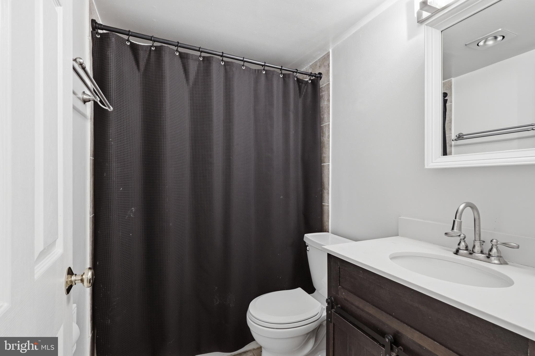 112 North Kennedy Road Sterling, VA 20164 - Photo 16 of 39 a bathroom with a sink a toilet a mirror and shower curtain
