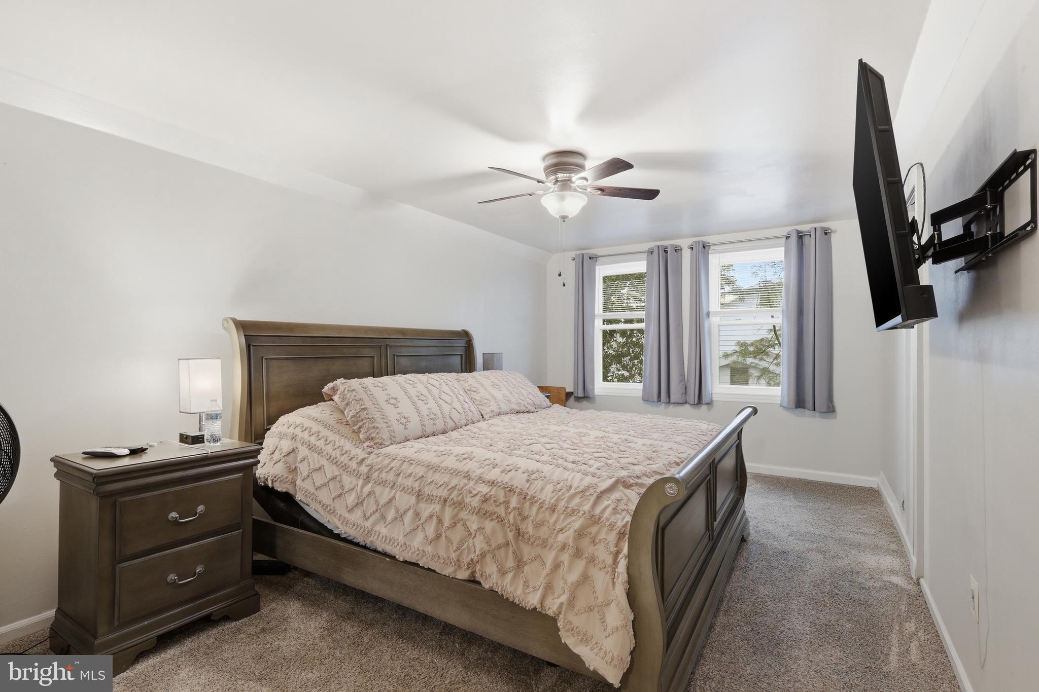 112 North Kennedy Road Sterling, VA 20164 - Photo 17 of 39 a bedroom with a large bed and a flat tv screen on dresser