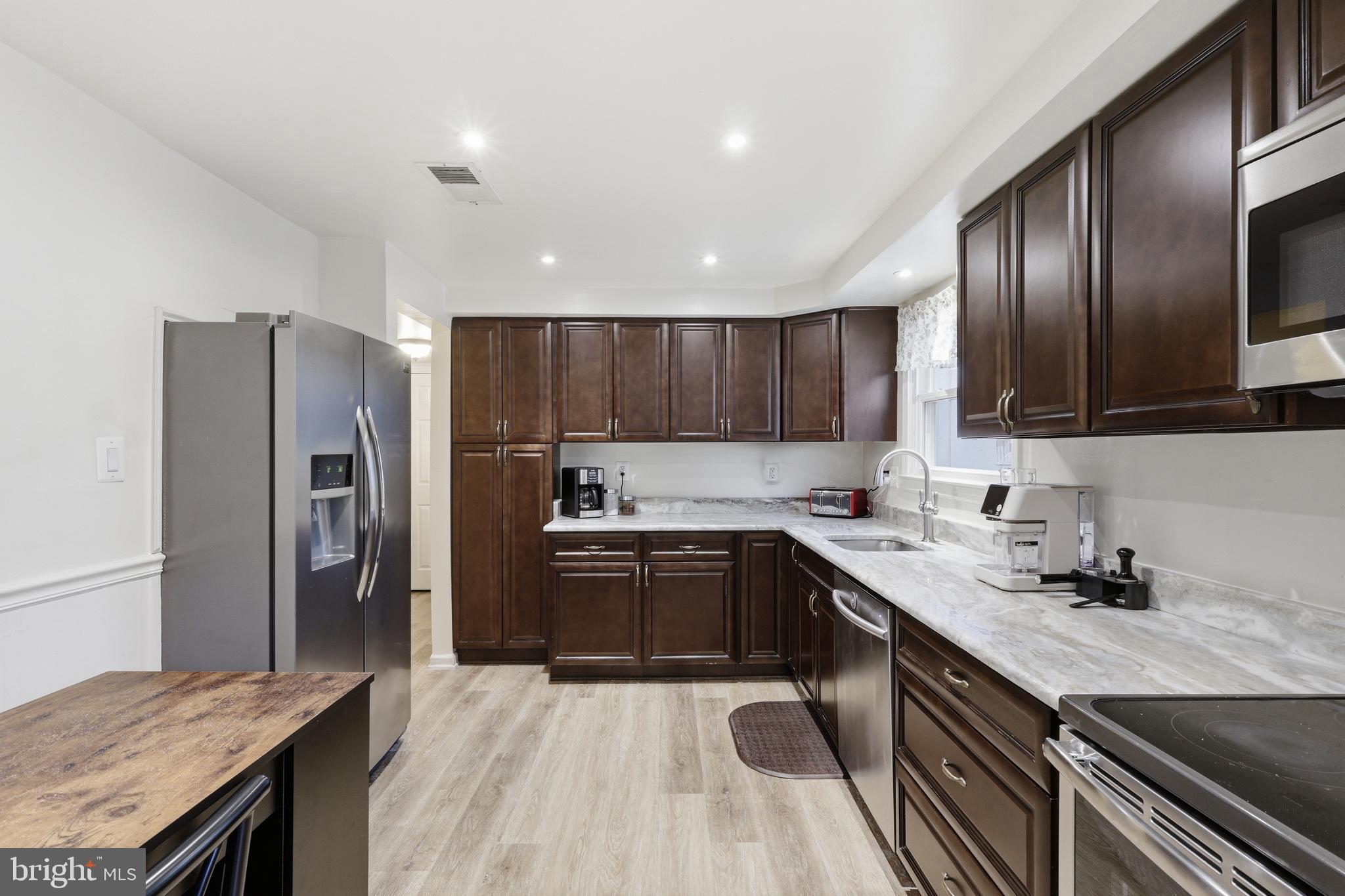 112 North Kennedy Road Sterling, VA 20164 - Photo 7 of 39 a kitchen with stainless steel appliances granite countertop a sink stove and refrigerator