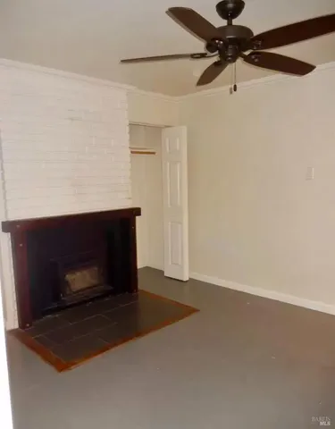 a room with a fireplace and a ceiling fan