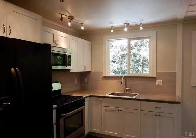 a kitchen with a sink a window and cabinets