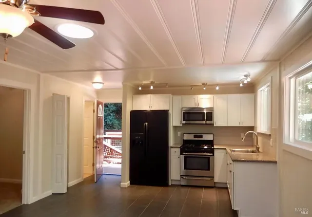 a kitchen with stainless steel appliances granite countertop a refrigerator and a stove top oven