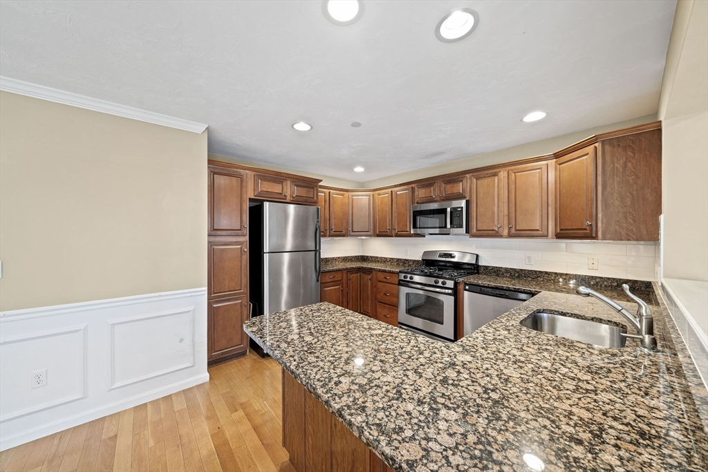 14 Red Pony Path, Unit 14 Marshfield, MA 02050 - Photo 5 of 40 a kitchen with stainless steel appliances granite countertop a stove top oven a sink dishwasher a refrigerator and cabinets with wooden floor