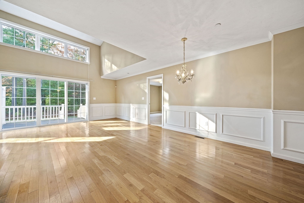 14 Red Pony Path, Unit 14 Marshfield, MA 02050 - Photo 9 of 40 a view of an empty room with wooden floor and windows