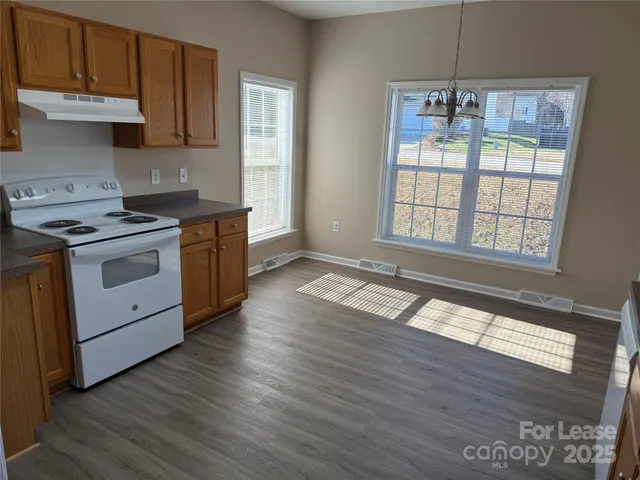 a kitchen with granite countertop wooden floors and stainless steel appliances