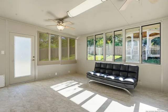 a living room with a large window and chandelier
