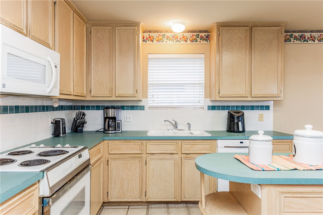 7306 Sun Valley Drive Corpus Christi, TX 78413 - Photo 11 of 40 a kitchen with stainless steel appliances granite countertop a sink stove and cabinets