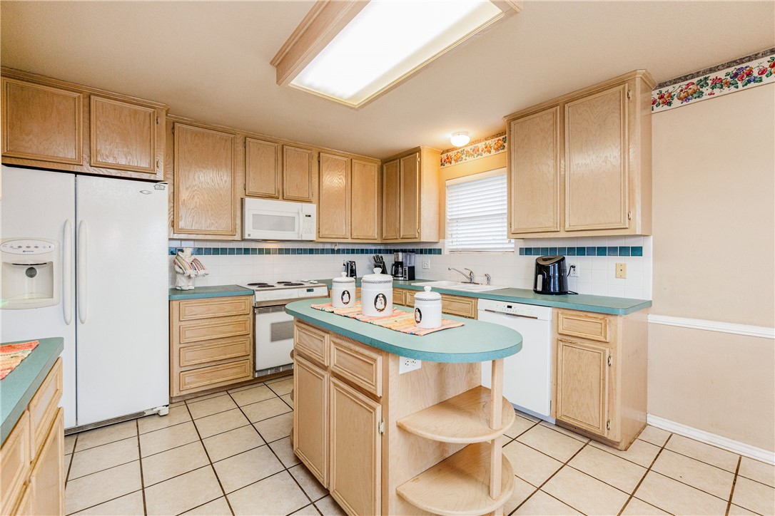 7306 Sun Valley Drive Corpus Christi, TX 78413 - Photo 14 of 40 a kitchen with a sink a stove a refrigerator and cabinets