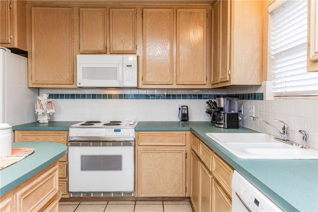 7306 Sun Valley Drive Corpus Christi, TX 78413 - Photo 15 of 40 a kitchen with a sink stove and cabinets
