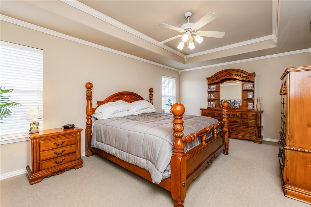 7306 Sun Valley Drive Corpus Christi, TX 78413 - Photo 18 of 40 a spacious bedroom with a bed and a ceiling fan