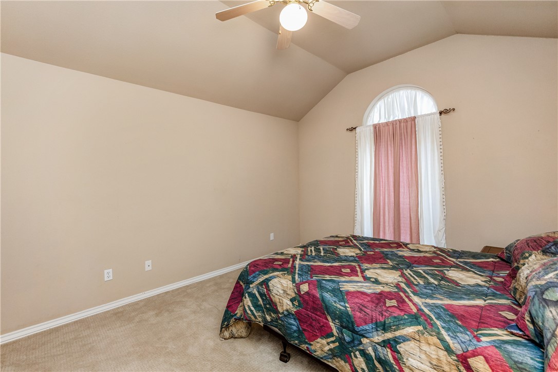 7306 Sun Valley Drive Corpus Christi, TX 78413 - Photo 30 of 40 a bedroom with a bed and a chandelier