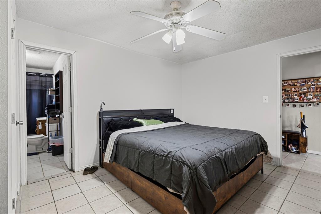 2002 Northeast Main Street Ennis, TX 75119 - Photo 21 of 30 a bedroom with a bed and a chandelier