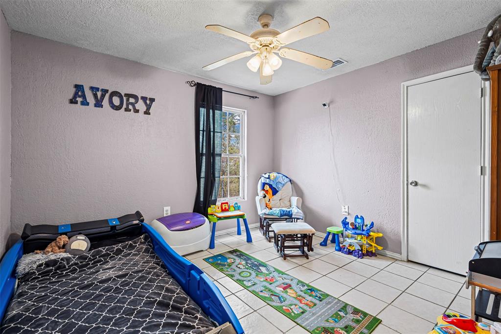 2002 Northeast Main Street Ennis, TX 75119 - Photo 23 of 30 a bed room with a bed and a wooden floor